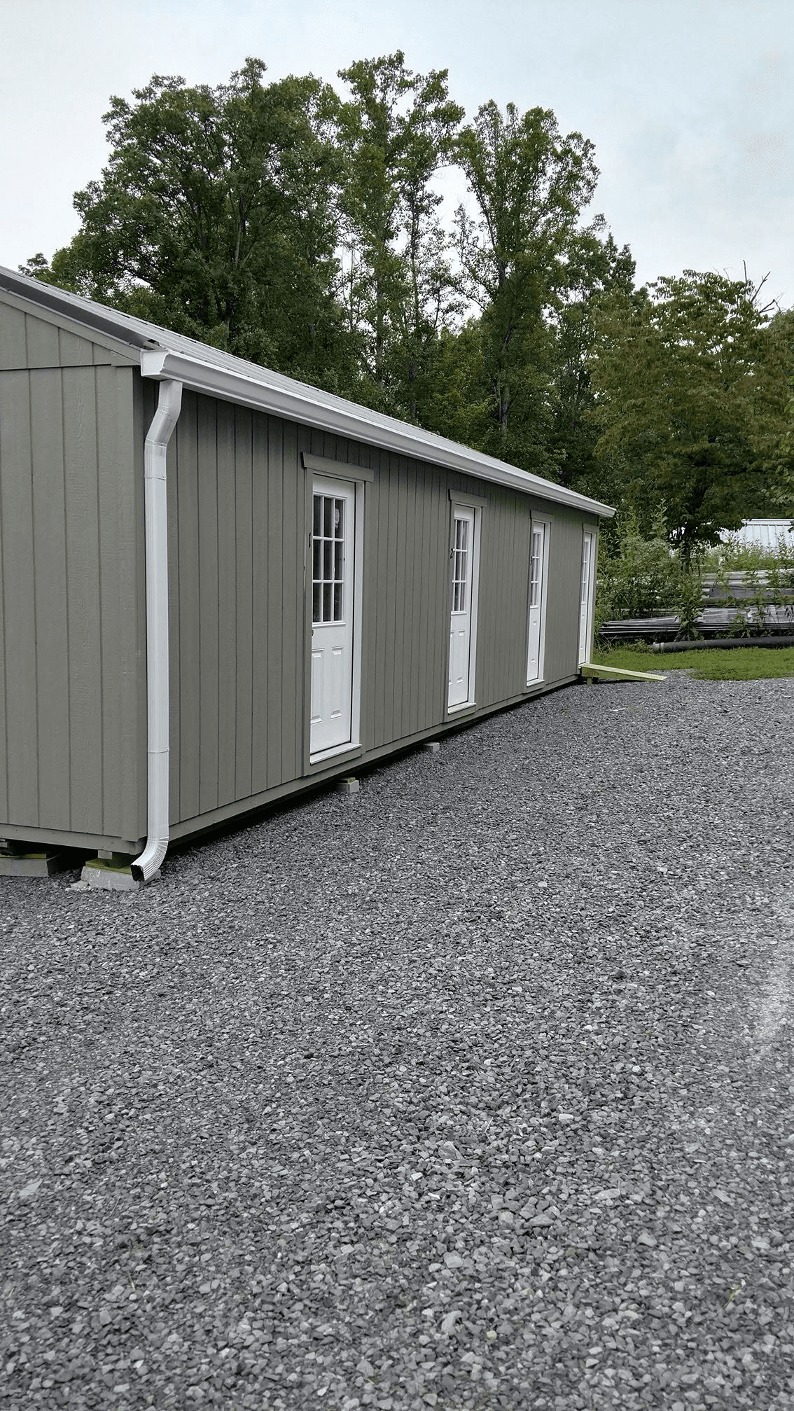 Gutter and downspout installation on a small shed